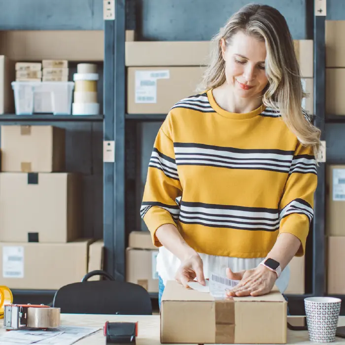 person sticking label to package